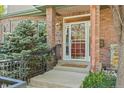 Inviting front door with decorative glass, brick facade, and manicured landscaping at 344 Saint Paul St, Denver, CO 80206