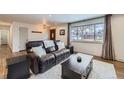 Living room with leather couch, coffee table, and large window at 7023 S Buffalo St, Littleton, CO 80120