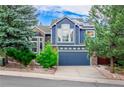 Charming blue two-story home with a well-maintained lawn and a two car garage on a sunny day at 1412 Pinyon Dr, Castle Rock, CO 80104