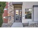Modern home entrance featuring a gray door, stone accents, and house number against a neutral facade at 3361 Mariposa St, Denver, CO 80211