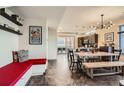 Open-concept living and dining area with a red bench seat, kitchen view, and modern lighting at 3361 Mariposa St, Denver, CO 80211