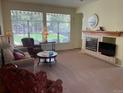 Comfortable living room featuring carpet, fireplace, and sun-filled windows overlooking the lawn at 9798 Grove St, Westminster, CO 80031