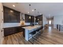 Kitchen featuring stainless appliances, a large center island with seating, and wood floors at 6759 Canyonpoint Rd, Castle Pines, CO 80108
