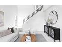 Stylish living room showcases a staircase, modern furnishings, and a decorative mirror at 8787 Yukon St, Arvada, CO 80005