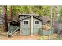 Two-story home featuring green siding, a covered deck, and a stone foundation at 1608 Beaver Brook Canyon Rd, Evergreen, CO 80439