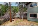 Charming exterior with mature trees and rustic charm nestled in a serene wooded setting at 1608 Beaver Brook Canyon Rd, Evergreen, CO 80439