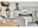 Bright kitchen featuring stainless hood, marble countertops, large island, and modern white cabinets at 4781 S Grant St, Englewood, CO 80113