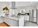 Modern kitchen boasts stainless steel appliances, a large island, and sleek white cabinetry at 4781 S Grant St, Englewood, CO 80113