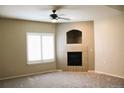 Bright living room with a ceiling fan, a large window, neutral-colored carpet, and a tile fireplace at 8603 E Dry Creek Rd # 211, Englewood, CO 80112