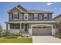 Charming two-story home featuring a covered front porch, gray exterior, and well-maintained landscaping at 11096 Endeavor Dr, Parker, CO 80134