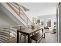 Open dining area featuring a modern table with seating, staircase, and access to the living room at 2620 S Delaware St # 3, Denver, CO 80223