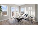 Bright living room featuring large windows, neutral tones, stylish décor, and hardwood floors at 2620 S Delaware St # 3, Denver, CO 80223