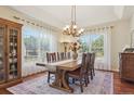 Elegant dining room with large windows, hardwood floors, and a rustic table at 4619 Mohawk Dr, Larkspur, CO 80118