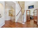 Inviting foyer with hardwood floors, staircase, and view into the living space at 4619 Mohawk Dr, Larkspur, CO 80118