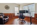 Comfortable home office featuring hardwood floors, wood paneling, and natural light at 4619 Mohawk Dr, Larkspur, CO 80118