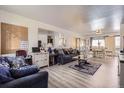 Bright living room area features nice wood flooring and large mirror at 1002 S Miller St, Lakewood, CO 80226