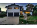 Charming two-story home with a well-maintained lawn, a two car garage and inviting curb appeal at 5611 W Bates Ave, Denver, CO 80227