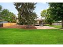 Spacious backyard with lush green grass and a large patio area at 655 Cree Cir, Boulder, CO 80303
