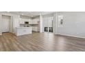 Bright open-concept living area featuring a modern kitchen with white cabinets and an island at 7245 Goldbloom Ln, Littleton, CO 80125
