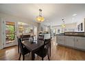 Open dining area with dark wood table, chairs, and lighting open to the kitchen at 1572 Leyden St, Denver, CO 80220