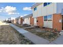 View of the townhomes and their front yards, showcasing a community-oriented layout at 1009 Milky Way, Thornton, CO 80260