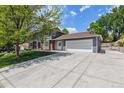 Spacious home featuring an attached garage and a well-manicured front yard, perfect for outdoor activities at 7359 S Jay St, Littleton, CO 80128