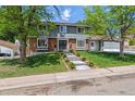 Charming two-story home with mature trees, a manicured lawn, and a welcoming front entrance with double doors at 7359 S Jay St, Littleton, CO 80128