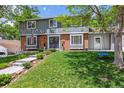 Charming two-story home with mature trees, a manicured lawn, and a welcoming front entrance with double doors at 7359 S Jay St, Littleton, CO 80128