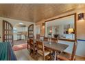 Dining room featuring decorative tin ceiling and an open view to kitchen and living room at 2309 E Floyd Pl, Englewood, CO 80113