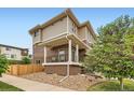 Back exterior showcasing a covered porch and a well-kept backyard with a stone landscape at 2592 Sweet Wind Ave, Castle Rock, CO 80109