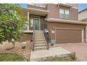 Home featuring a front entrance with stairs leading up to the front door and a two-car garage at 2592 Sweet Wind Ave, Castle Rock, CO 80109