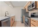 A closer view of the kitchen and its stainless steel appliances and herringbone backsplash at 3141 S Tamarac Dr # 111G, Denver, CO 80231