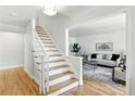 Bright entryway featuring hardwood floors, a staircase, and a glimpse into the living room at 3884 S Niagara Way, Denver, CO 80237