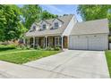 Attractive home featuring a stone facade, manicured lawn, and an attached two-car garage at 3884 S Niagara Way, Denver, CO 80237