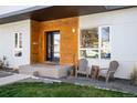 Inviting front entrance with a wood accent wall, stylish seating, and well-maintained landscaping at 1265 Niagara St, Denver, CO 80220