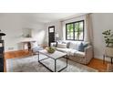 Bright living room features hardwood floors, modern decor, and a large window at 1411 S Beach Ct, Denver, CO 80219