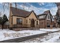 Charming brick home featuring a stone entryway and well-maintained landscaping on a snow-covered lawn at 475 S Race St, Denver, CO 80209