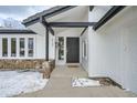 Modern front entrance with a black door and stone accents at 2133 S Parfet Dr, Lakewood, CO 80227