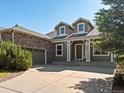 Charming two-story home featuring stone accents, dormer windows, and a welcoming front porch at 7254 S Kellerman Way, Aurora, CO 80016