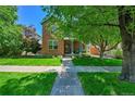 Inviting brick home with a well-manicured lawn and mature trees, creating a welcoming curb appeal at 7064 E 2Nd Ave, Denver, CO 80220