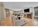 Spacious living room featuring a cozy fireplace, hardwood floors, and ample natural light at 7064 E 2Nd Ave, Denver, CO 80220