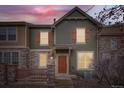 Inviting two-story townhome featuring a stone facade, wood accents, and a cozy front porch at 821 Stony Mesa Pl, Castle Rock, CO 80108