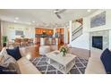 Open-concept living room with wood floors, fireplace, and view to kitchen and dining area at 786 Sundance Ln, Erie, CO 80516