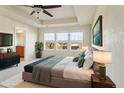 Bright main bedroom with tray ceiling, large windows, and ensuite bathroom at 786 Sundance Ln, Erie, CO 80516