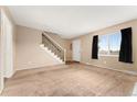 Inviting living room with carpet, staircase, neutral tones, and ample natural light at 4555 S Lowell Blvd, Denver, CO 80236