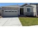 Charming single-Gathering home featuring stone accents, a two-car garage, and a well-manicured lawn at 1957 S Coolidge Way, Aurora, CO 80018