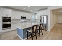 Modern kitchen featuring white cabinets, stainless steel appliances, and an island at 18455 W 94Th Ave, Arvada, CO 80007