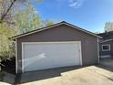 View of the large detached garage with white door and neutral siding at 1129 2Nd Ave, Longmont, CO 80501
