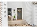 Charming covered front porch with decorative wreath on the front door and exterior decor at 6686 E Jamison Ave, Centennial, CO 80112