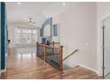 Hallway showcasing hardwood floors, staircase, and access to the living room at 8802 E 148Th Ln, Thornton, CO 80602